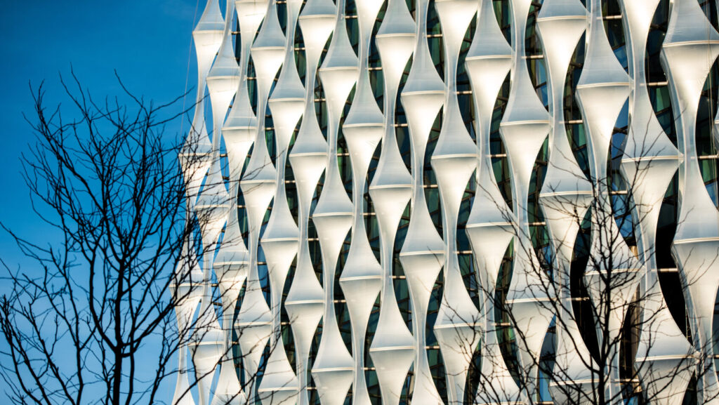 Sunlit exterior panels of the U.S. Embassy in London against a blue sky.